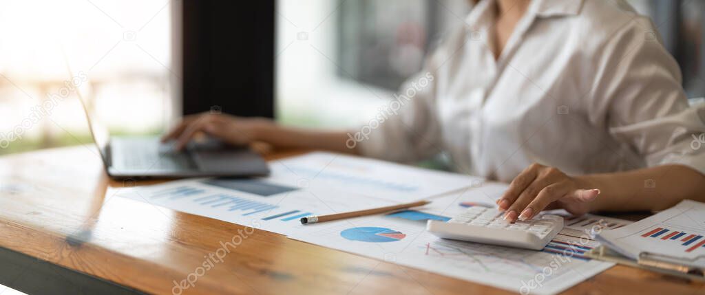 Businessman analyzing investment charts with calculator laptop. Accounting and technology in office.Business people using laptop at office,Analyze plans