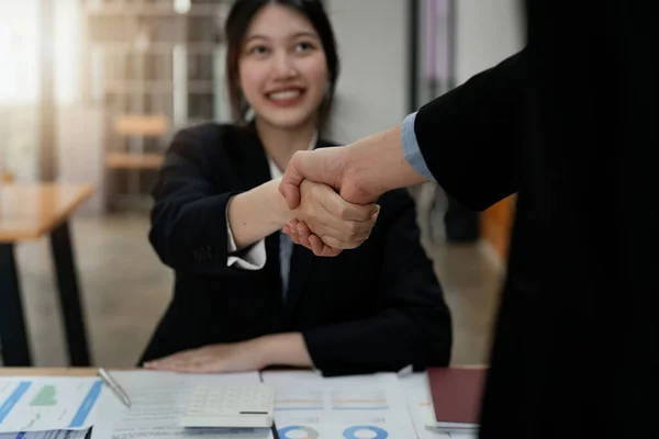 Dos empresarios se dan la mano después de aceptar una propuesta de negocio juntos, un apretón de manos es un homenaje universal, a menudo utilizado en el saludo o felicitaciones. —  Fotos de Stock