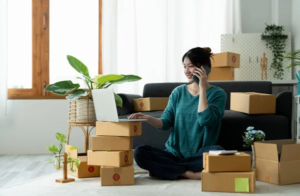 Business owner writing address on cardboard box at workplace. freelance woman seller prepare parcel box of product for deliver to customer. Online selling, e-commerce, shipping concept — Stock Fotó