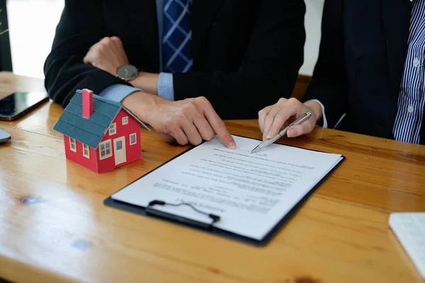 Fastighetsmäklare talade om villkoren i bostadsköpeavtalet och bad kunden att underteckna dokumenten för att göra avtalet lagligt, Hemförsäljning och hemförsäkring koncept — Stockfoto