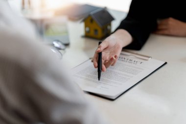 Emlakçı ev tasarımını ve satın alma anlaşmasını görmeye gelen müşterilere ev tarzını anlatıyor.