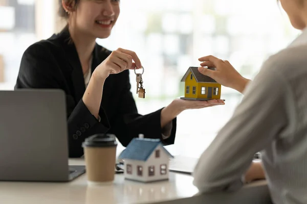 Immobilienmakler hält Hausschlüssel für seinen Mandanten nach Vertragsunterzeichnung im Büro, Konzept für Immobilien, Umzug oder Vermietung von Immobilien — Stockfoto