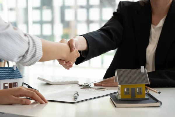 Corretor imobiliário e cliente apertando as mãos após a assinatura de um contrato: imobiliário, empréstimo de casa e conceito de seguro — Fotografia de Stock
