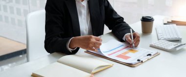 İş kadını, ofis, vergi, muhasebe, istatistik ev muhasebe konsepti gibi ahşap masa üzerinde matematik finansmanı için hesap makinesi kullanıyor.
