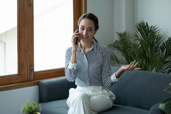 Привлекательная азиатская деловая женщина разговаривает по мобильному телефону с клиентом . — стоковое фото