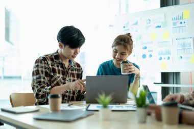 Bir grup genç yaratıcı Asyalı iş birliği ofis brifinginde çeşitli takımlarla işbirliği yapıyor, çift ırklı iş adamı toplantısına odaklanıyor, iş fikirlerini iş arkadaşlarıyla toplantıda görüşüyorlar.