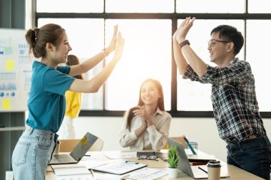 Modern ofisteki çok ırklı, yaratıcı genç insanlar. Bir grup genç iş adamı dizüstü bilgisayar, tablet ve defterle birlikte çalışıyor. Birlikte çalışan başarılı bir hipster takımı. Bağımsızlar