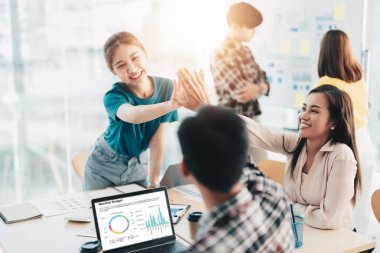 Modern ofisteki çok ırklı, yaratıcı genç insanlar. Bir grup genç iş adamı dizüstü bilgisayar, tablet ve defterle birlikte çalışıyor. Birlikte çalışan başarılı bir hipster takımı. Bağımsızlar