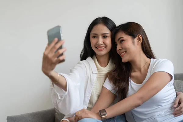 亚洲漂亮的女同性恋或朋友用手机在沙发上自拍。LGBT 、技术和生活方式概念. — 图库照片