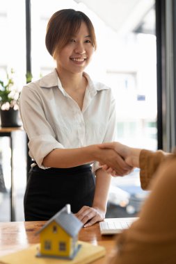 Başarılı bir anlaşma, gayrimenkul, ev satın alma sözleşmesi konsepti, ofiste sözleşmeyi imzaladıktan sonra banka çalışanlarıyla el sıkışan alıcı