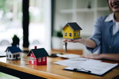 Emlakçı anahtar ve ev modeli ev, ev satın alma konsepti veriyor..