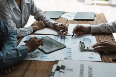 İş ekibi yeni fikir projesini sunuyor. Ekonomik rapor grafiği ve verileri incelemek için iş adamı tartışıyor ve toplanıyor.