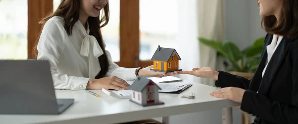 Agente imobiliário experiente mostrando modelo de casa para o cliente e pronto para assinar contrato — Fotografia de Stock