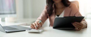 Ofisteki mali raporlar ve dizüstü bilgisayarla çalışan iş kadınını kapat.