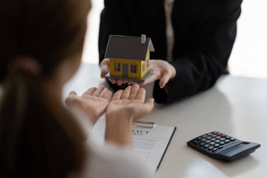 Ev ve gayrimenkul ticareti. Emlakçı ev sahibine anahtarları veriyor.