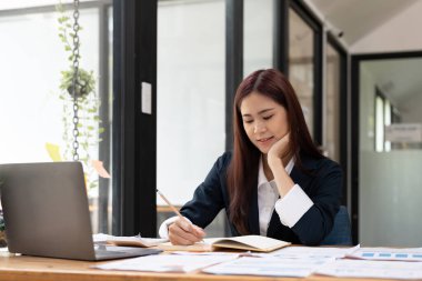 İşletme muhasebecisi Asyalı kadın, ofis ve iş geçmişinde, vergi, muhasebe, istatistik ve analitik araştırma konseptinde matematik finansmanı için hesap makinesi kullanıyor..