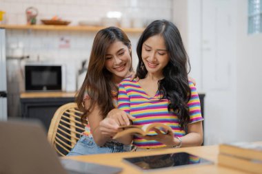 Mutlu lezbiyen lgbtq çifti birbirlerine aşık, gülüyorlar evde eğleniyorlar. İki farklı sevgi dolu kadının kucaklaşması, kaynaşması. Lgbt ilişki kavramı.