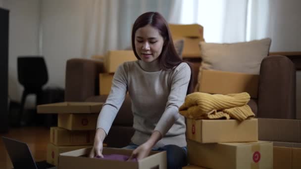 幸せなアジアの女性は自宅でのオンラインショッピングの後に梱包小包を受け取る — ストック動画