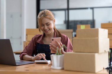 Asyalı kadın, Boxs laptop ve Online satıcı alışverişi için çalışan genç Asyalı kadınların KOBİ girişimcisine sahipti, çevrimiçi pazarlama teslimatı KOBİ-ticaret kavramı.