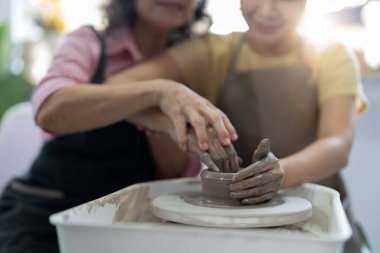 Çömlek atölyesi. Sunbae, genç Asyalı kadın çömlekçilik öğretmeni. Çamur modelliği.