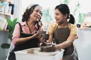 Çömlek atölyesi. Sunbae, genç Asyalı kadın çömlekçilik öğretmeni. Çamur modelliği.