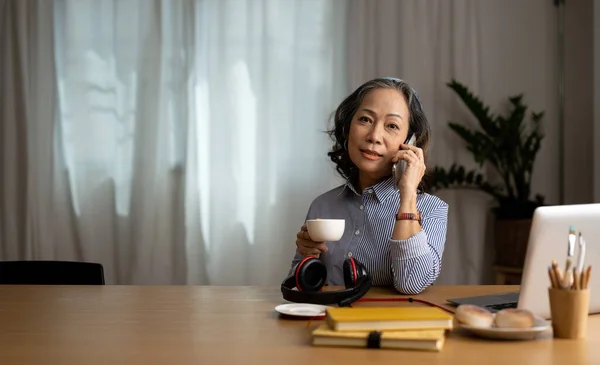 Старшая Азиатка Разговаривает Мобильному Телефону Обсуждая Отчет Помощью Ноутбука Концепция — стоковое фото