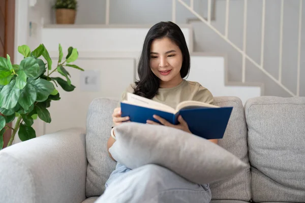 Feliz Asiático Jovem Mulher Sentado Sofá Leitura Livro Casa Pessoas — Fotografia de Stock