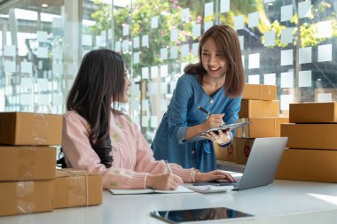 iş dijital çevrimiçi küçük işletme online mağaza için günümüzde yeni bir başlangıç. İki kadın sahibinin müşterilerine gönderdikleri bir depo var. KOBİ girişimci kavramı.