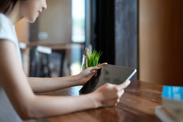 close up hands multitasking woman using tablet, laptop at cafe shop.