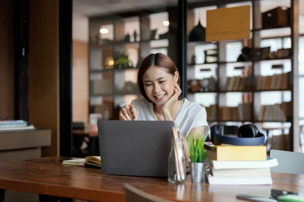 Happy young asian woman involved in educational video call conference conversation, studying remotely, consulting with teacher using laptop computer application