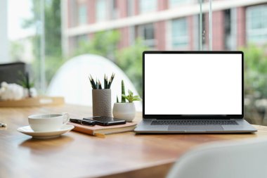 Laptop boş ekran sehpanın üzerinde kahve kafesi arka planı, maketi, metnin şablonu, kırpma yolları dahil.