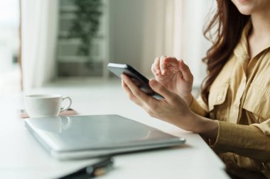 Ofisinde akıllı telefon kullanan bir iş kadınının elini kapat..