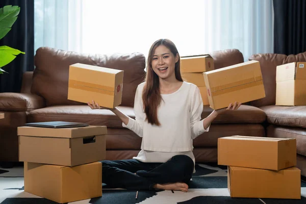 Small business parcel for shipment to client, Young asian woman received online shopping parcel opening boxes and buying items by credit card, online marketing on purchase order package product.