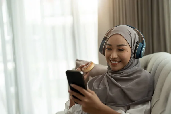Mulher Muçulmana Asiática Bonita Usando Telefone Celular Enquanto Sentado Sofá — Fotografia de Stock