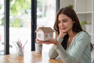 Emlakçı ev modelini ve evin anahtarını elinde tutuyor. Mortgage Gayrimenkul Yatırım ve Sigorta Konsepti