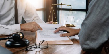 sözleşme imzalama ve mahkeme ofis, yasal hizmet kavramı masa üzerinde yasal danışmanlar, dizüstü bilgisayar ve ahşap Yargıç tokmak ile noter veya adalet avukat ile iş tartışırken istemci müşteri