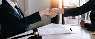 Avukatın müvekkille el sıkışması hukuk bürosundaki anlaşmayı onaylamak ve tebrik etmek için.