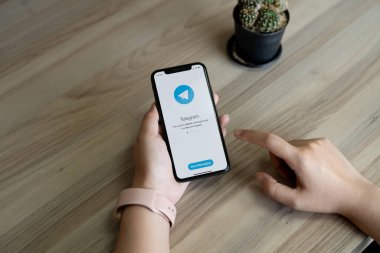 CHIANG MAI, THAILAND, JUL 12, 2022 : Woman hand holding iPhone X with social networking service Telegram on the screen. iPhone 10 was created and developed by the Apple inc
