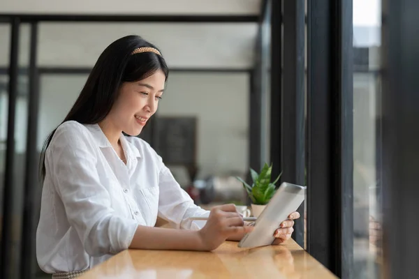 Young Asian Woman Using Digital Tablet While Sitting Her Office — ストック写真