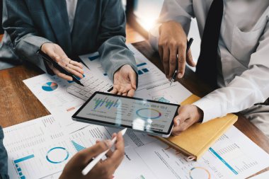 İşletme danışmanlığı ortaklığı ortakları şirketin mali durumunun grafiğini çıkarmak için tablet kullanıyorlar..