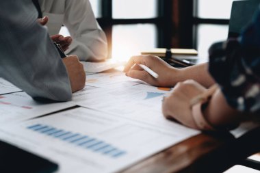 İş dünyası finans ya da muhasebe uzmanı, iş veri özeti raporunu, ofisteki muhasebe belgesini, iş toplantısı kavramını hesaplamak için hesap makinesi ile çalışıyor..