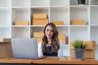 Küçük işletme girişimcisi KME, kutuda kumaş paketleyen Asyalı kadın. Portre genç Asyalı küçük işletme sahibi ev sahibi, çevrimiçi satış pazarlama teslimatı, KME e-ticaret tele pazarlama kavramı.