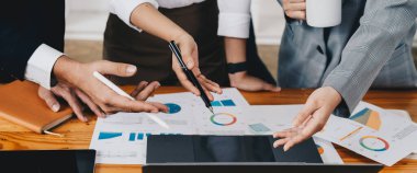 Bir grup iş ortağı modern iş yerinde fikirleri ve planları tartışıyor..