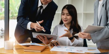 Bir grup iş ortağı modern iş yerinde fikirleri ve planları tartışıyor..