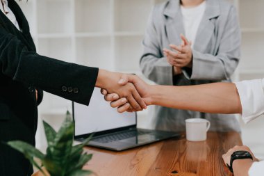 Millennial businessmen colleagues shaking hands on meeting in office, diverse enterpreneurs striking good deal, multiethnic teammates succeed in common project work.