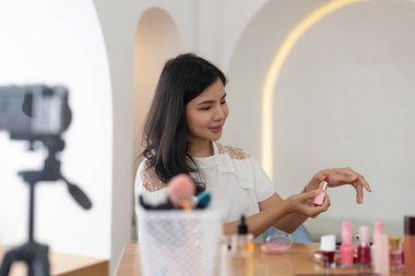 Asya genç kadın blogger ile makyaj kozmetik concept.live sosyal medya akışı üzerinde ev online etkileyen viral, vlog video kayıt.