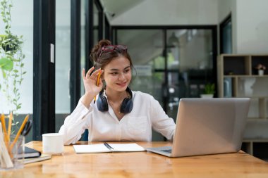 Online education, e-learning. young woman studying remotely, using a laptop, listening to online webinar at home.