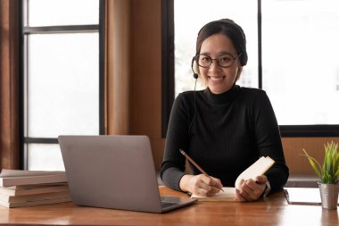 Attractive female student learning language, watching online webinar, listening audio course, e-learning education concept.