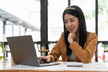 Business asian woman using laptop computer for financial report.