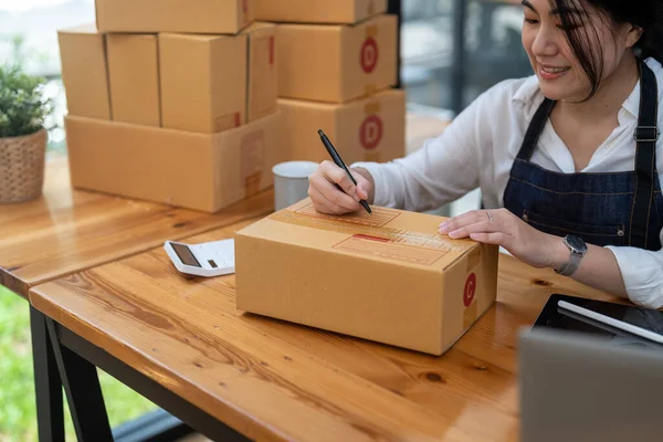 Smiling Entrepreneur Writing Delivery Box Table — Foto de Stock
